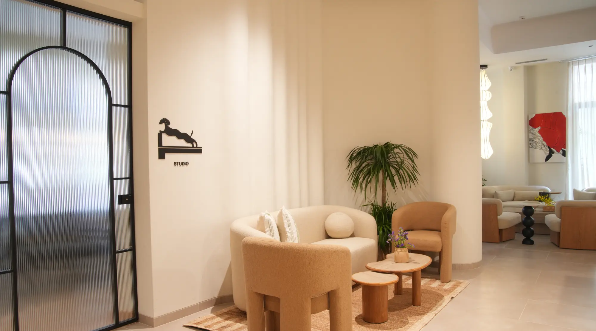 The lounge at Unlock Everyday, with an arched glass door and warm seating