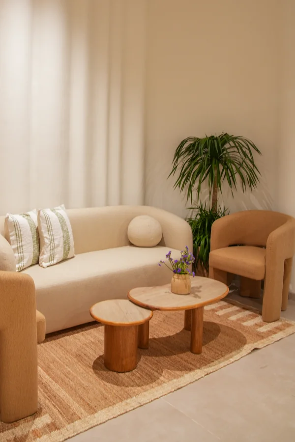A cozy seating nook at Unlock Everyday with a sofa, armchair and travertine coffee tables