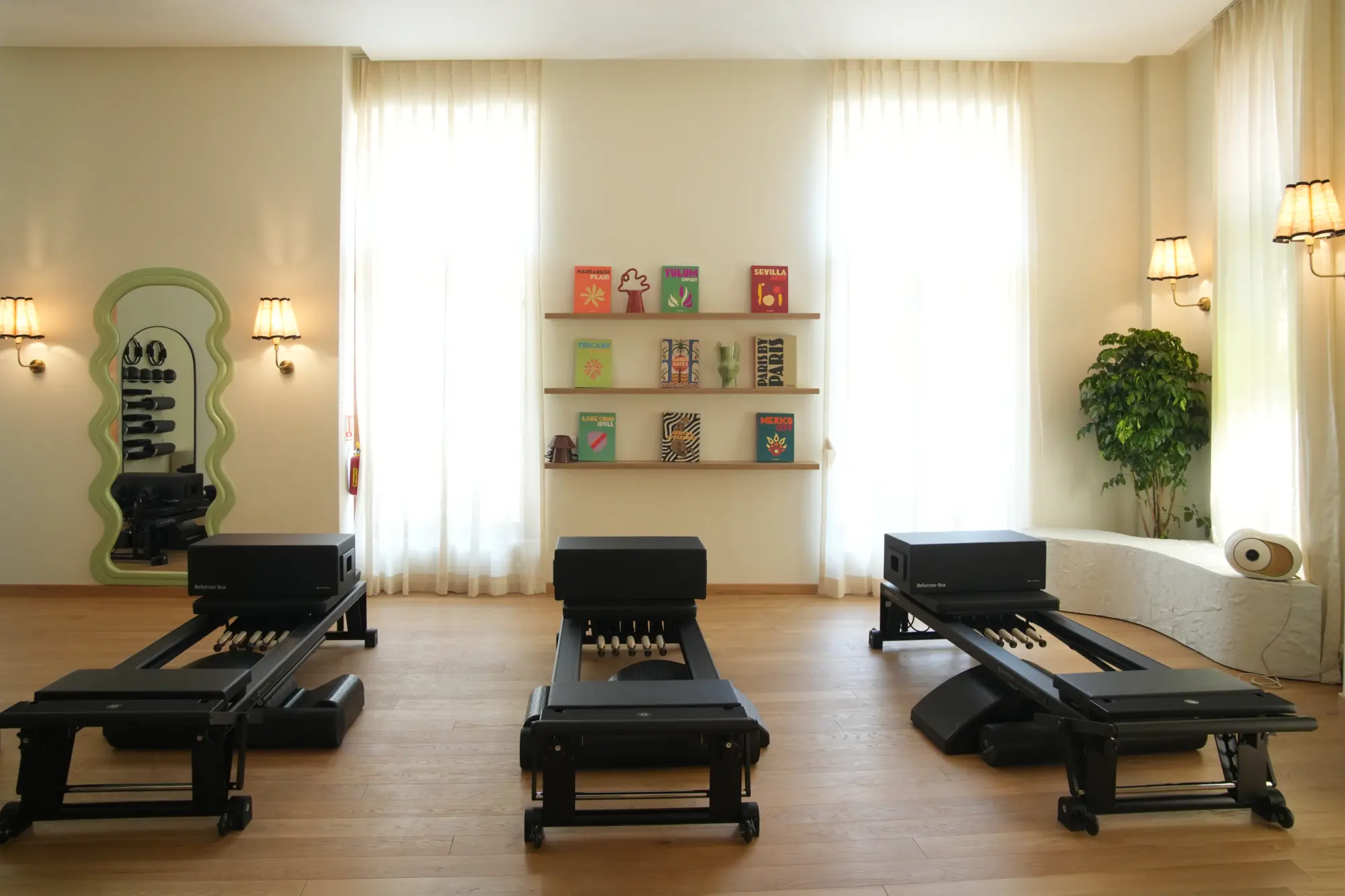 The Unlock Everyday Pilates studio, with reformer machines, warm oak floors and soft natural light